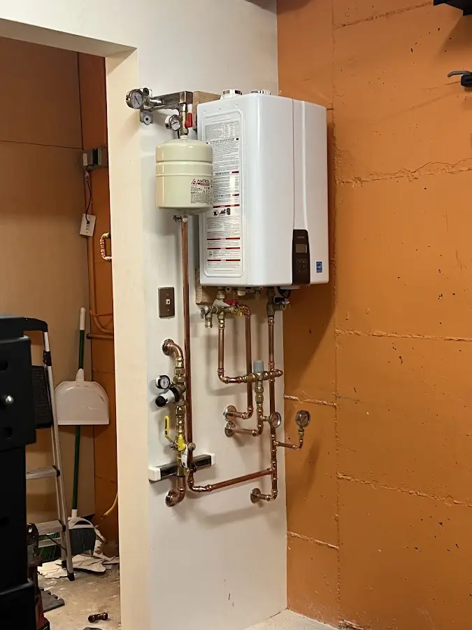 Plumbing technician inspecting water heater connections in Wilson